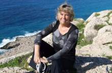 Greta sitter på en klippa vid havet, Cypern